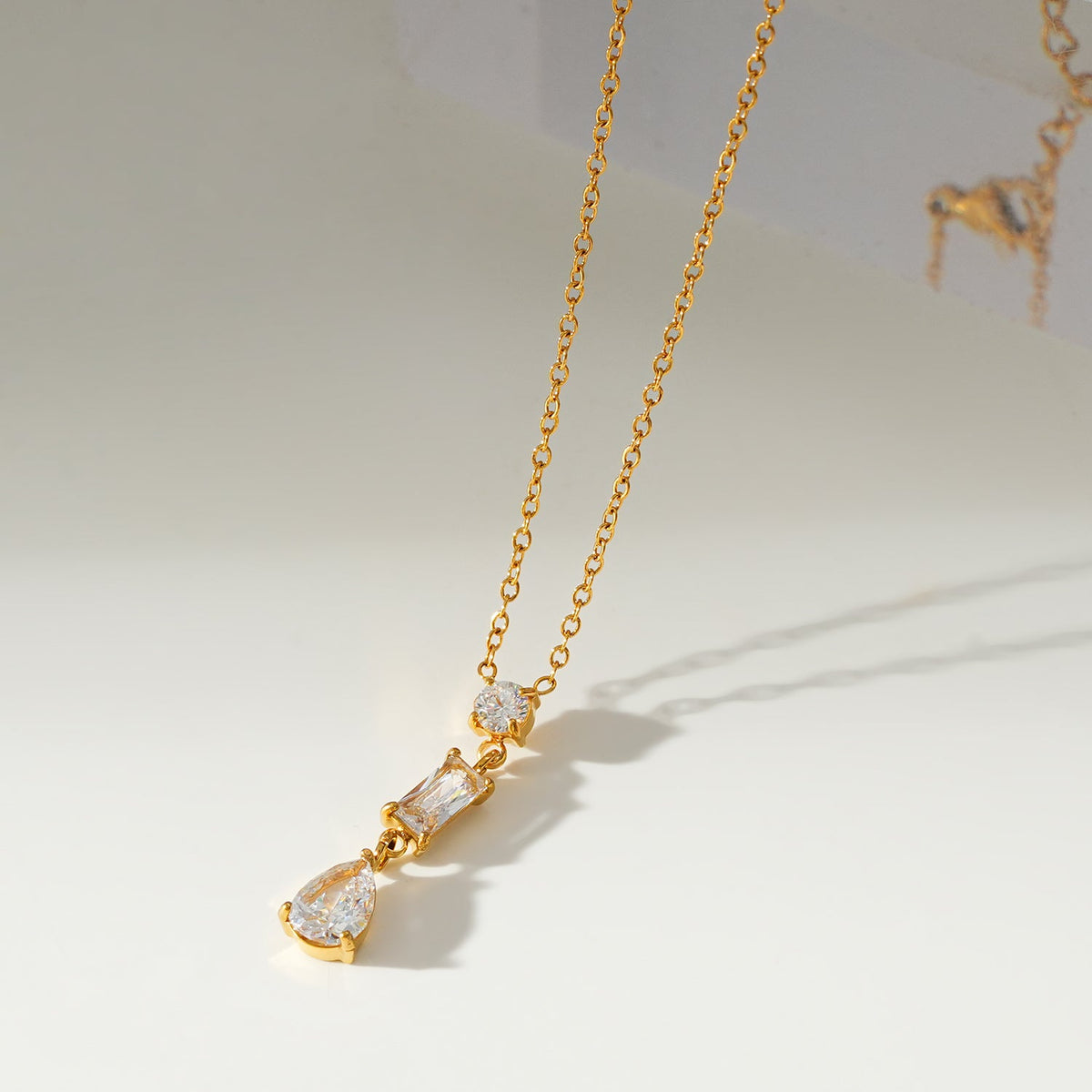 Style ROCHINA Or : Un collier à pendentif avec trio de charms en oxyde de zirconium